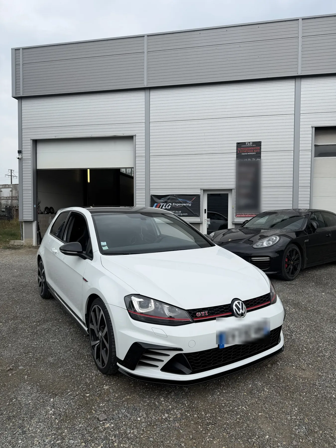 Façade de l’atelier TLG Engineering à Benfeld, une Golf GTI Clubsport et une Porsche Panamera garées devant