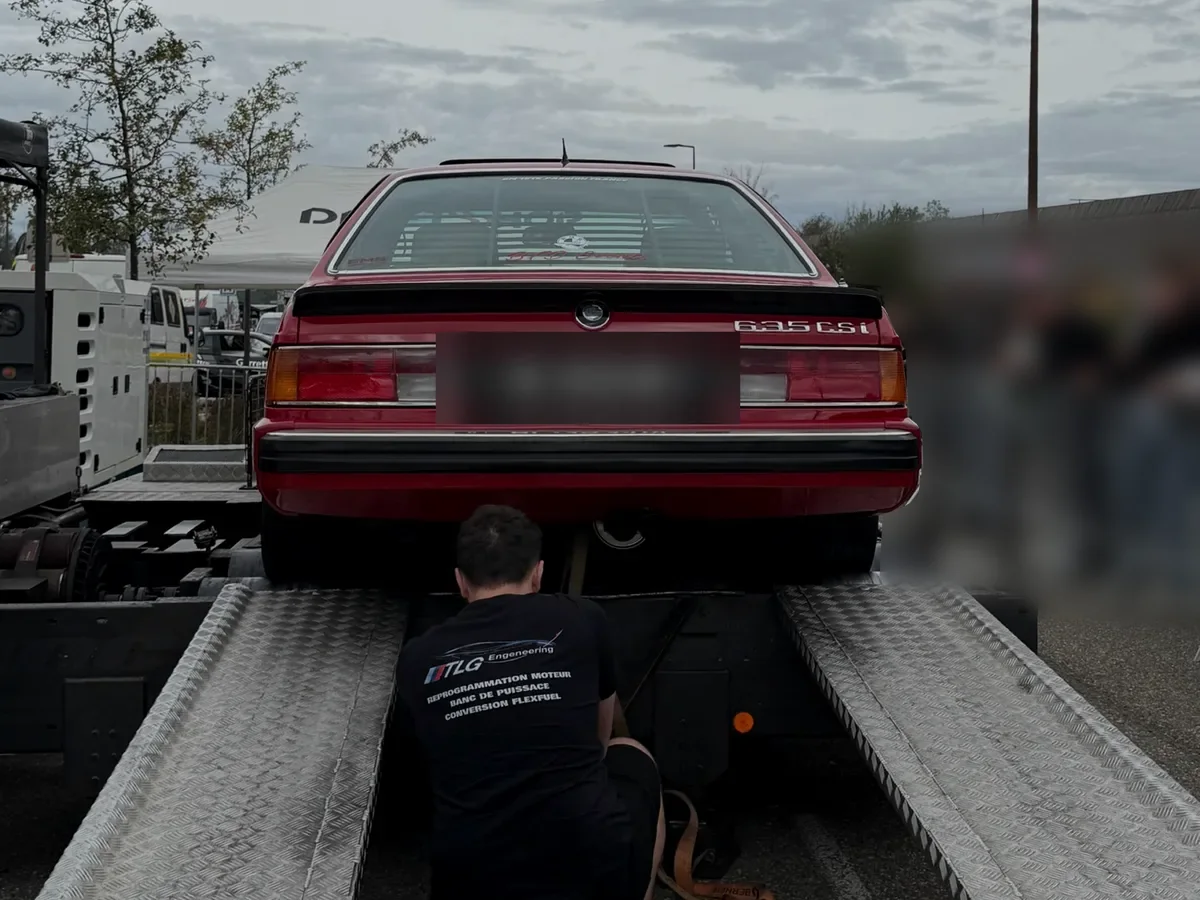 Un technicien TLG sangle une BMW 635 CSi sur le banc de puissance TLG, lors d’une journée banc